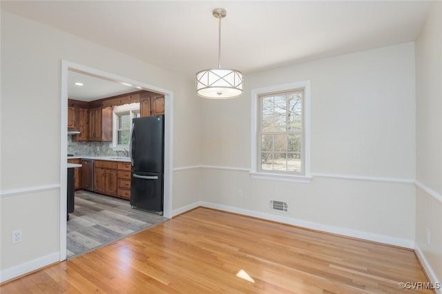 interior space featuring visible vents, baseboards, recessed lighting, a sink, and light wood-type flooring