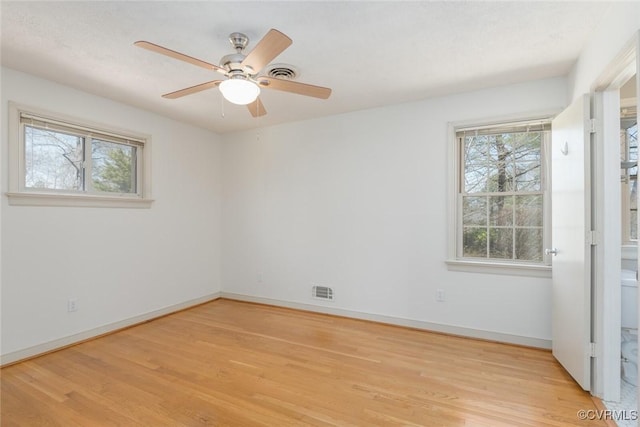 unfurnished room featuring visible vents, baseboards, light wood-style floors, and a ceiling fan