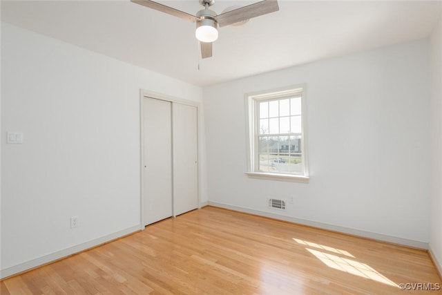 unfurnished bedroom featuring a closet, visible vents, light wood-type flooring, and baseboards