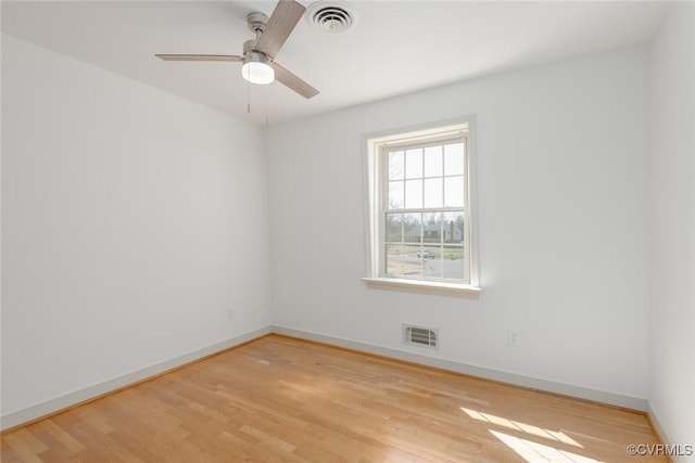 empty room with light wood-type flooring, visible vents, baseboards, and ceiling fan