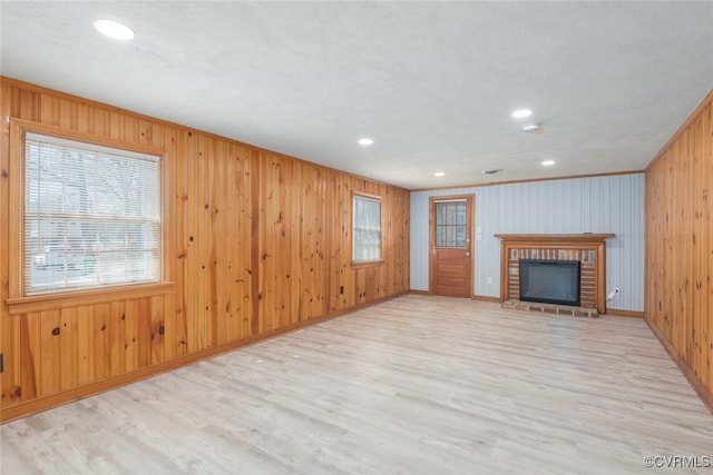 unfurnished living room with light wood finished floors, recessed lighting, a fireplace, and baseboards