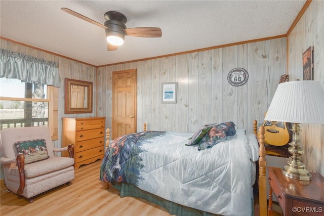 bedroom featuring ceiling fan, a textured ceiling, wood finished floors, and crown molding