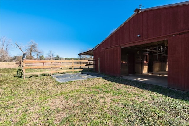 view of yard featuring an outdoor structure, a rural view, and an exterior structure