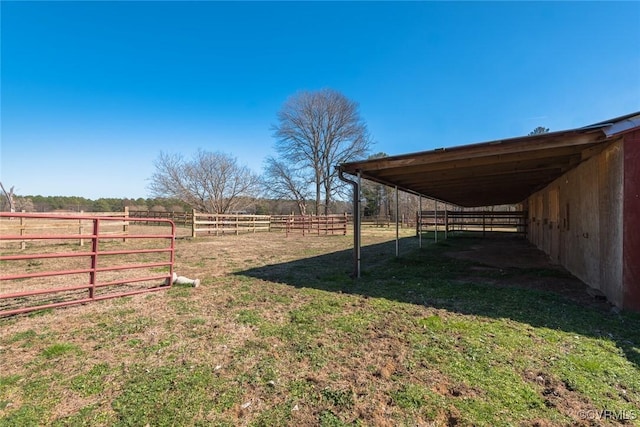 view of yard featuring an outbuilding, a rural view, an exterior structure, and a carport