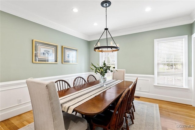 dining space featuring plenty of natural light, a wainscoted wall, and ornamental molding