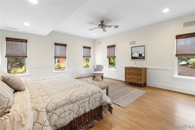 bedroom with wood finished floors, baseboards, visible vents, a baseboard radiator, and recessed lighting