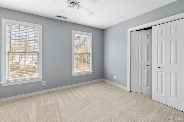 unfurnished bedroom featuring visible vents, a ceiling fan, a closet, carpet flooring, and baseboards