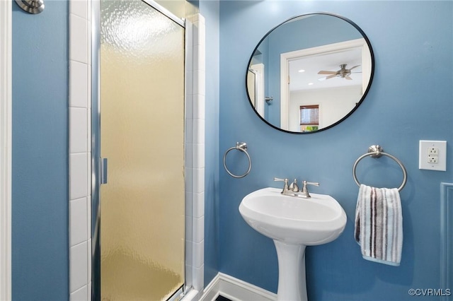 full bathroom featuring a shower stall and baseboards