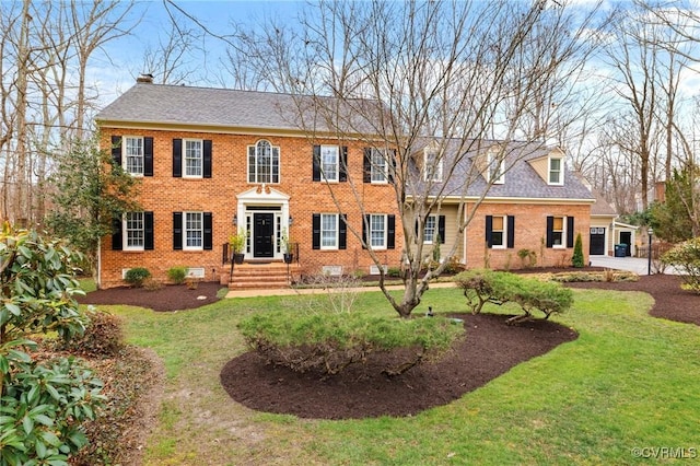 view of front of property featuring a front yard, brick siding, and a shingled roof