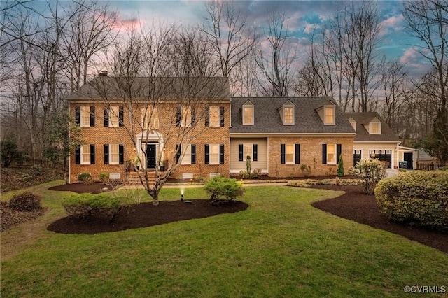 view of front of home featuring a garage, roof with shingles, a front yard, crawl space, and brick siding