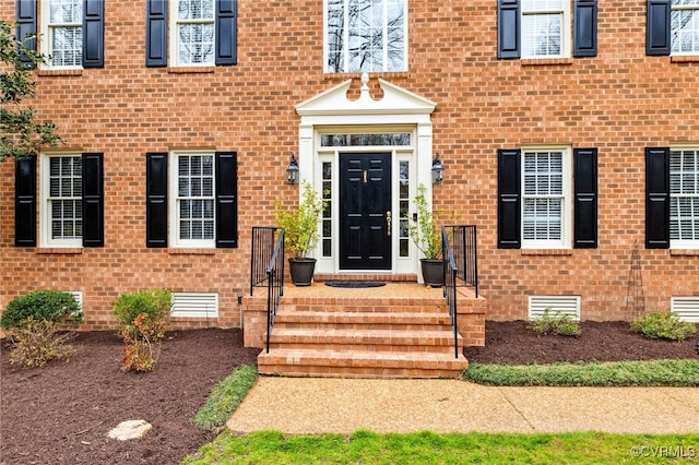 entrance to property with crawl space and brick siding