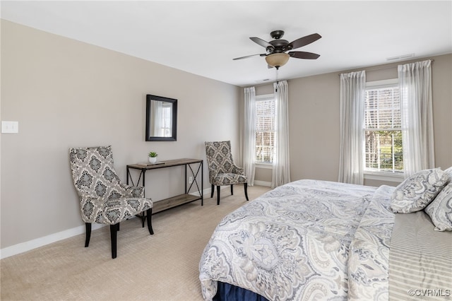 bedroom featuring light carpet, visible vents, multiple windows, and baseboards