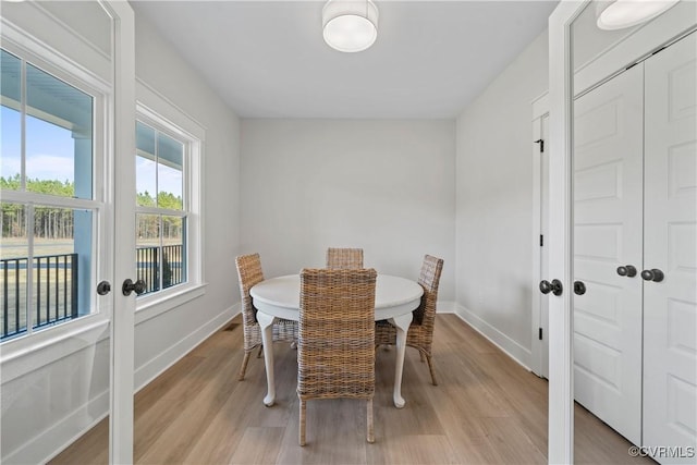 dining room featuring light wood-style flooring and baseboards