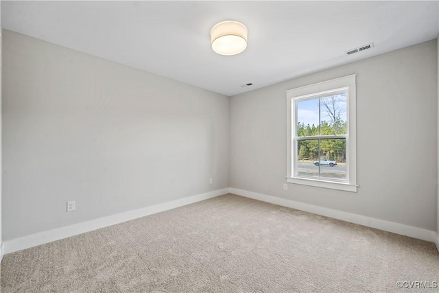 unfurnished room with visible vents, baseboards, and carpet flooring