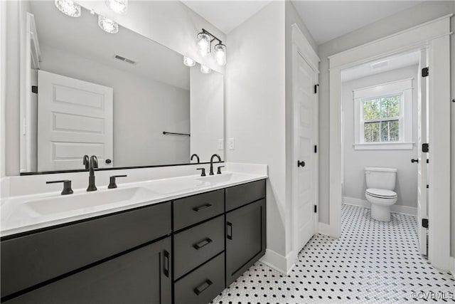 full bathroom with a sink, visible vents, baseboards, and double vanity