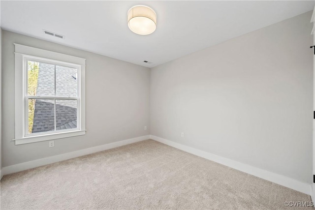 carpeted spare room featuring baseboards and visible vents