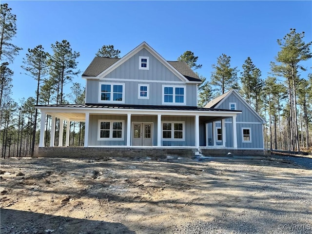 view of front of property featuring board and batten siding, a porch, french doors, metal roof, and a standing seam roof