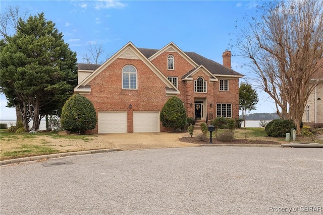 view of front facade with a garage, brick siding, concrete driveway, and a chimney