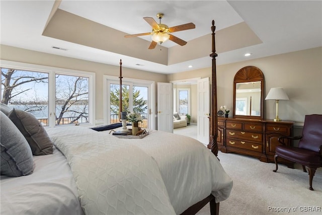 bedroom featuring a ceiling fan, visible vents, recessed lighting, light carpet, and a raised ceiling