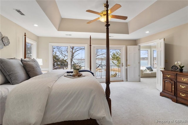 bedroom with recessed lighting, a tray ceiling, carpet, and access to exterior