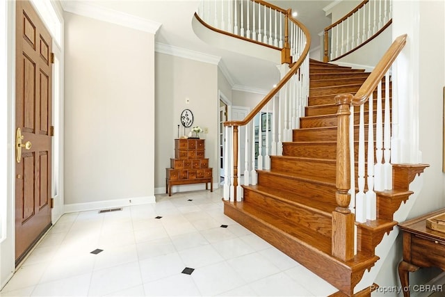 entryway with visible vents, stairway, crown molding, and baseboards