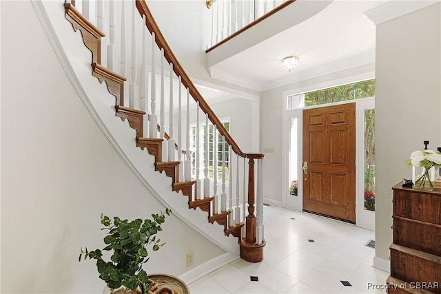 entrance foyer with crown molding, baseboards, and a wealth of natural light