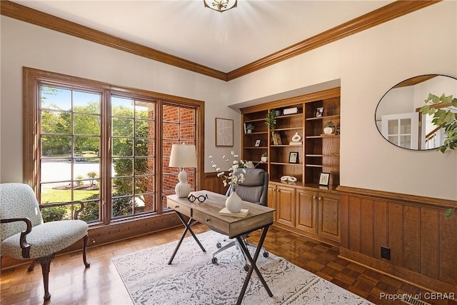 office area with a wainscoted wall, ornamental molding, and wood walls