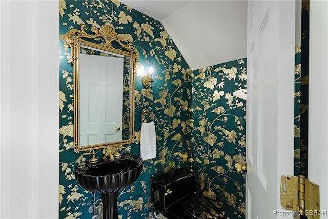 bathroom with a sink and wallpapered walls