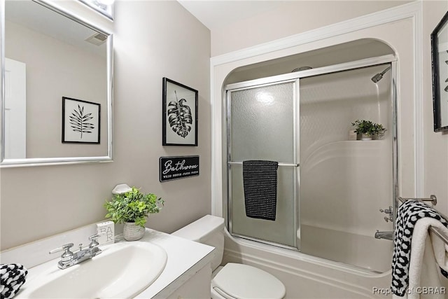 bathroom with visible vents, toilet, vanity, and bath / shower combo with glass door