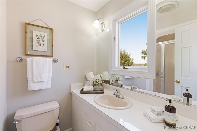 bathroom with vanity, a shower stall, and toilet