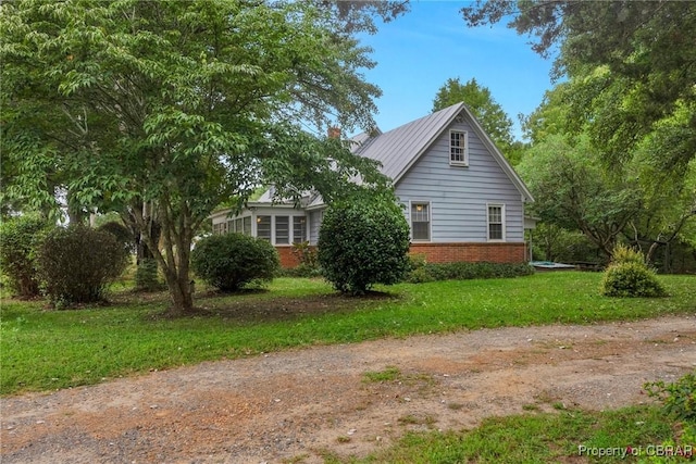 view of property exterior with a yard, brick siding, and a chimney