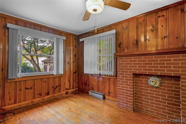 interior space with visible vents, light wood-style floors, wood walls, and a ceiling fan