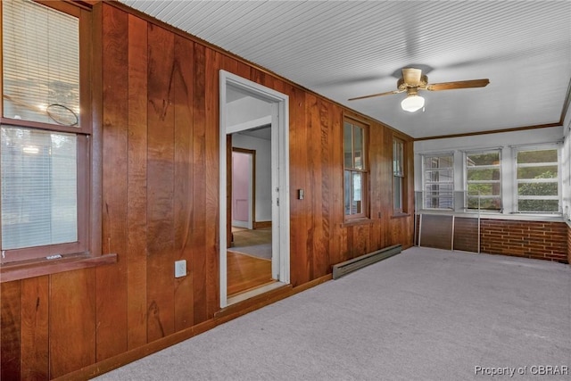 unfurnished sunroom featuring a baseboard heating unit and a ceiling fan