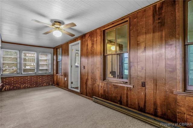 unfurnished sunroom featuring a baseboard heating unit and a ceiling fan