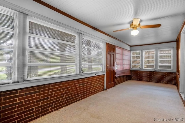 unfurnished sunroom with ceiling fan