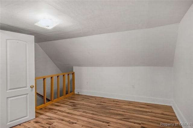 bonus room featuring vaulted ceiling, baseboards, and wood finished floors