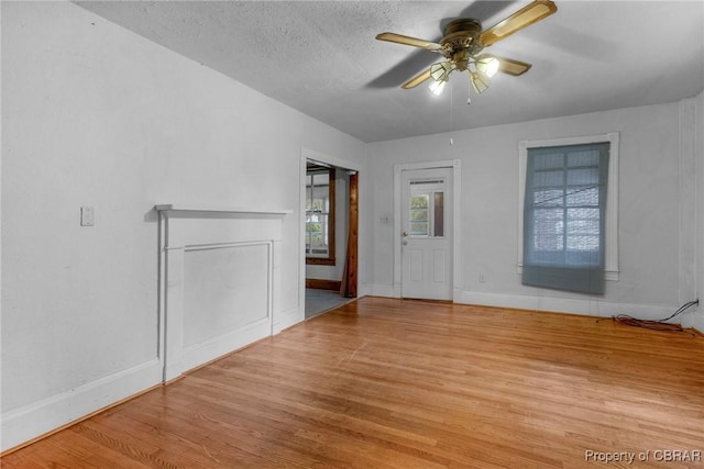 spare room featuring ceiling fan, baseboards, a textured ceiling, and wood finished floors