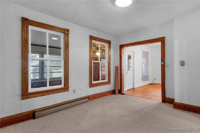 carpeted spare room featuring baseboards and baseboard heating