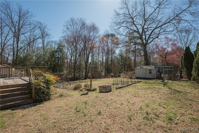 view of yard with a storage unit, an outbuilding, and a deck