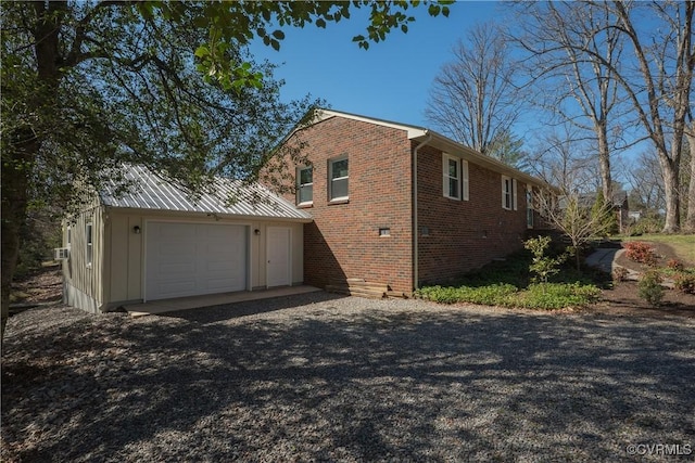 view of property exterior featuring brick siding, an attached garage, and driveway