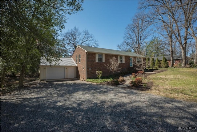 view of front of house with a front lawn, an attached garage, brick siding, and driveway