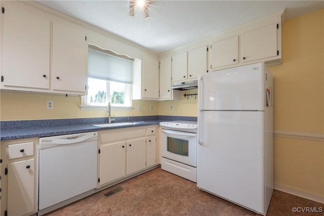 kitchen with white appliances, visible vents, a sink, under cabinet range hood, and dark countertops