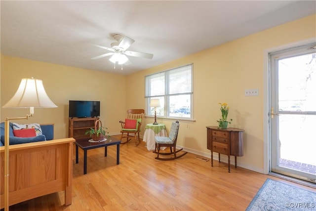 sitting room with light wood finished floors, visible vents, a ceiling fan, and baseboards