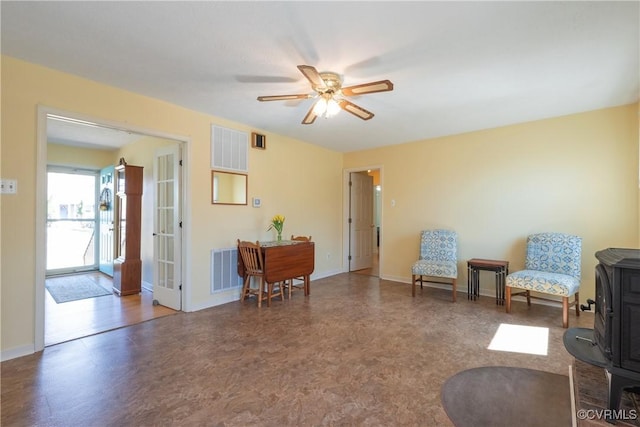 living area with visible vents, baseboards, and ceiling fan