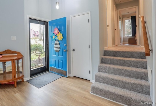 foyer with stairway, baseboards, and wood finished floors