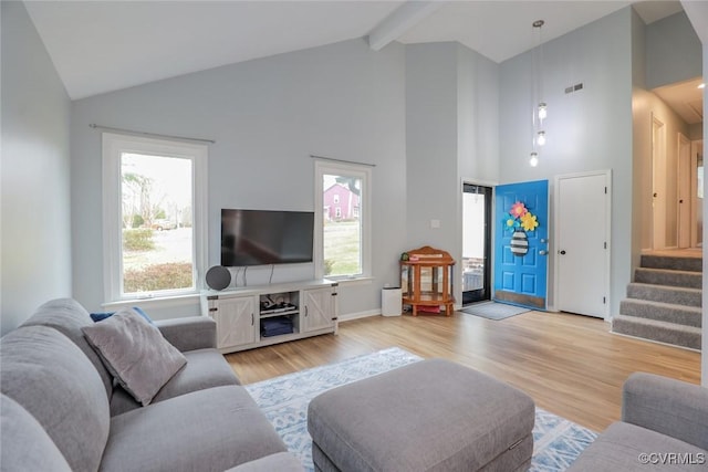 living room featuring stairs, beam ceiling, wood finished floors, and high vaulted ceiling