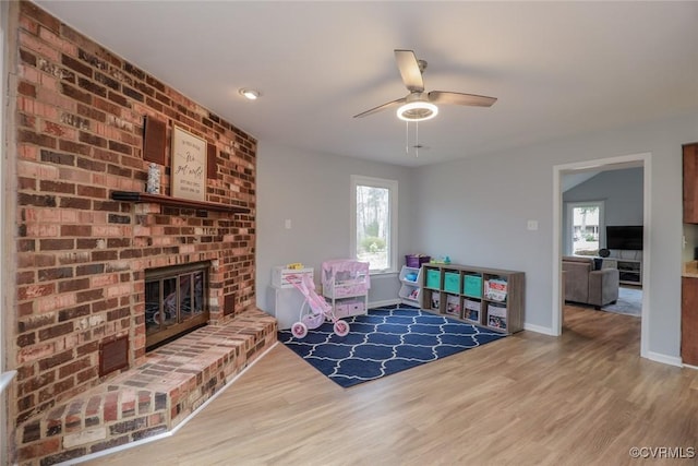 interior space featuring a wealth of natural light, a brick fireplace, and wood finished floors