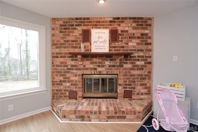 room details featuring wood finished floors, a fireplace, and baseboards