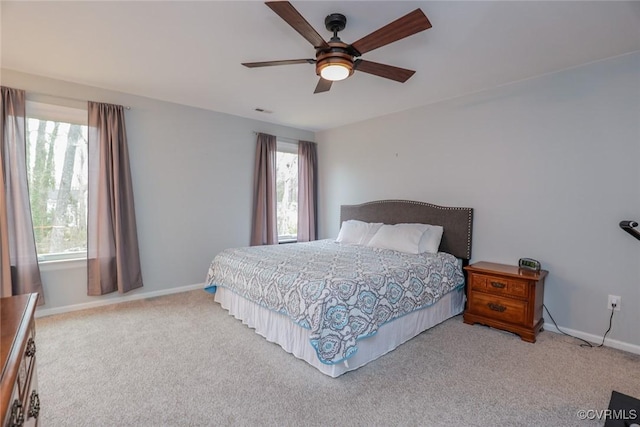 carpeted bedroom featuring visible vents, baseboards, and ceiling fan