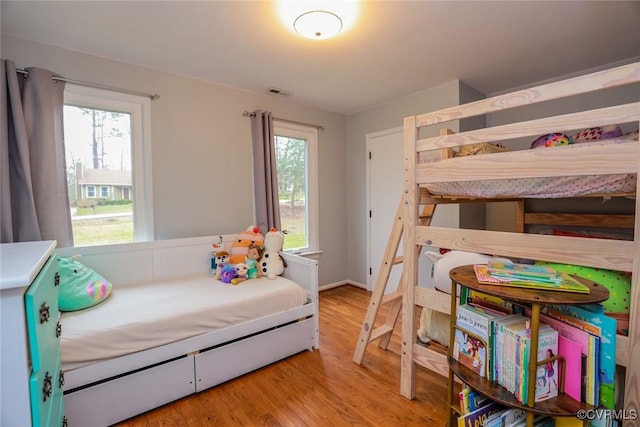 bedroom featuring wood finished floors and visible vents